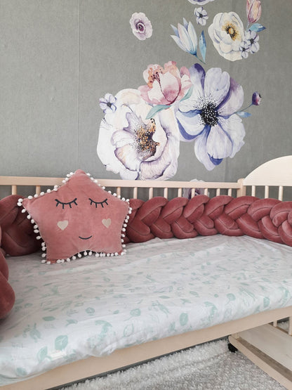 Fresia Double Braided Bumper with gray star pillow on the crib. Front side slightly angled from the left