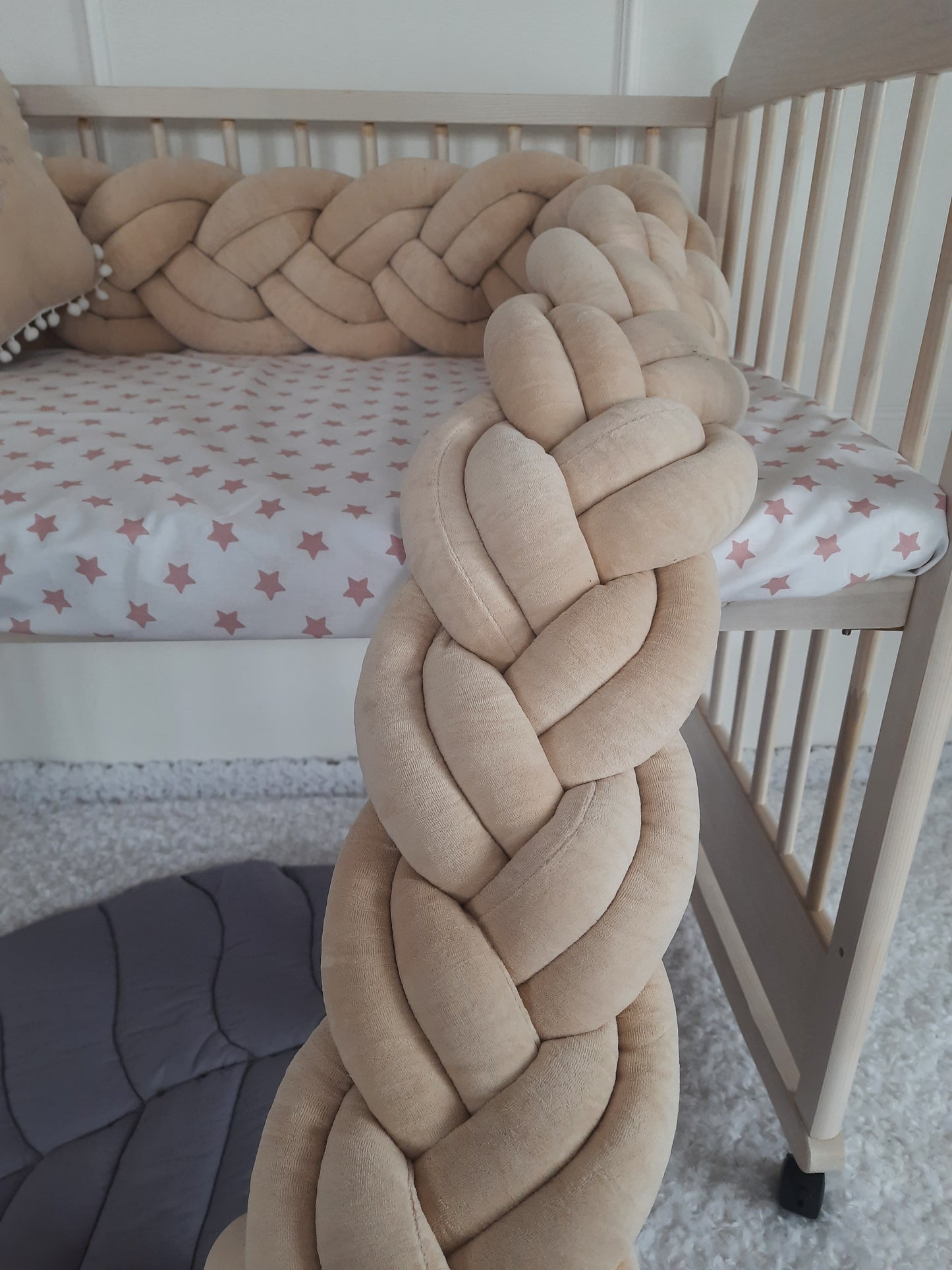 Braided crib bumper in coffee color. Close-up view