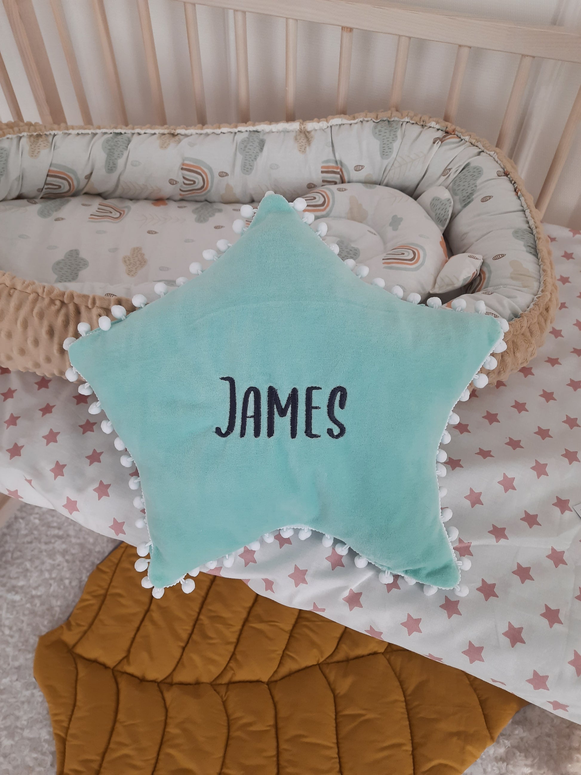 Blue star pillow and embroidered baby name James. Star pillow is a gift with the purchase of a braided bumper