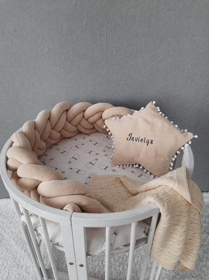 Short double braided crib bumper in cream color and star pillow with embroider of baby name on the circular crib