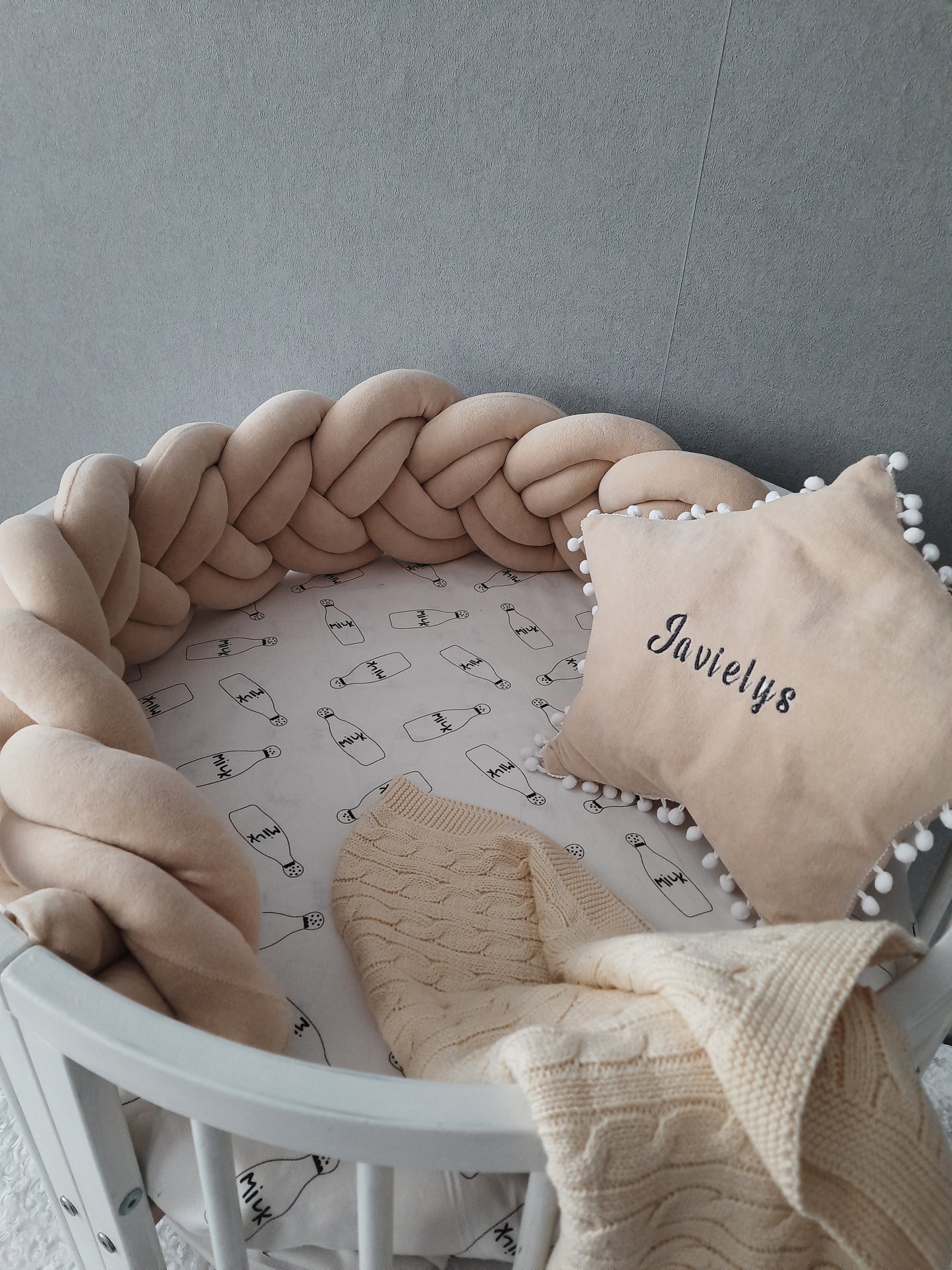 Short double braided crib bumper in cream color and star pillow with embroider of baby name on the circular crib