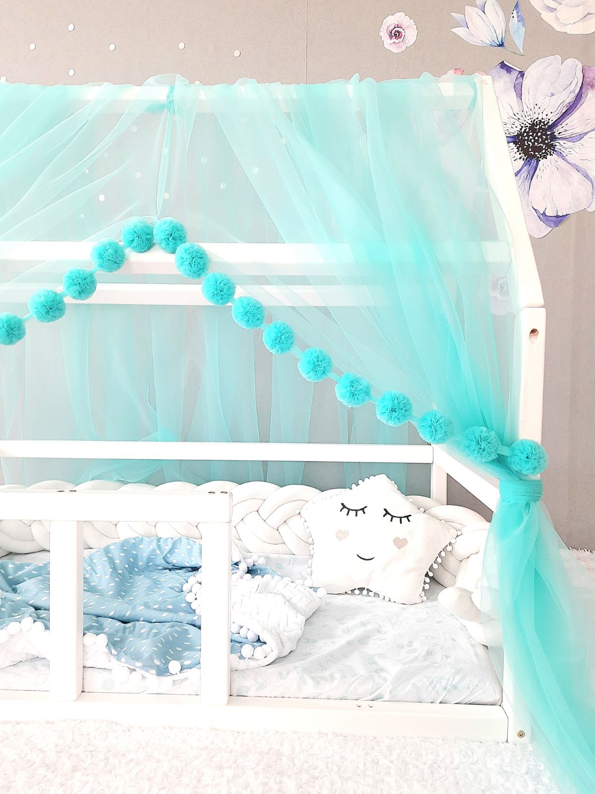 Tulle montessori canopy for crib. Braided cot bumper, star pillow and blanket on the bed. 