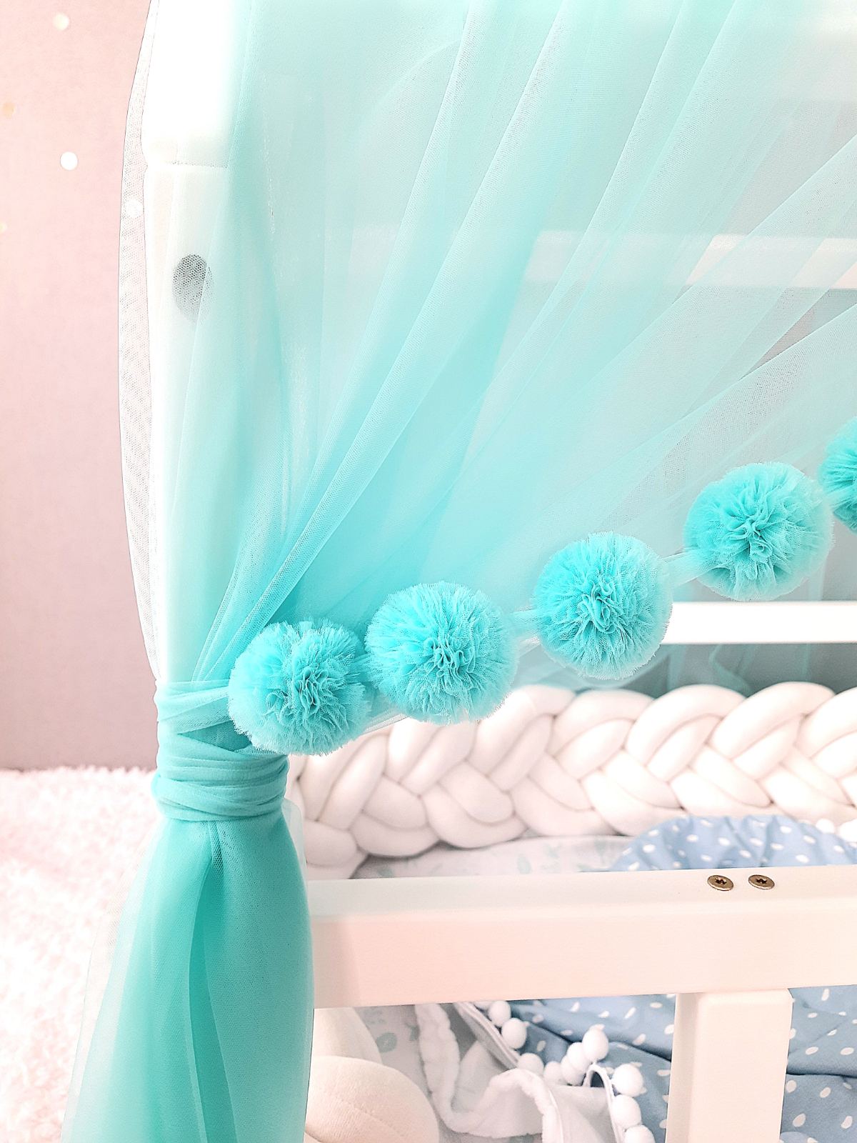 Aqua montessori tulle canopy with pom poms. Close up view