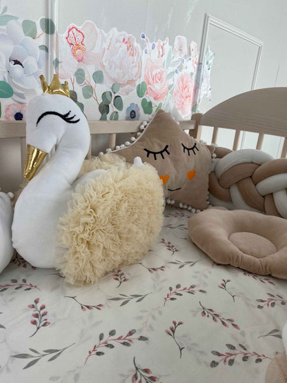 Swan and star pillows on the crib.