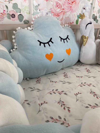 Blue cloud pillow with cute face on the crib