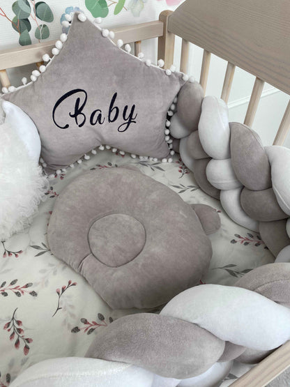 Light gray Orthopedic Infant Pillow and star pillow on the crib 