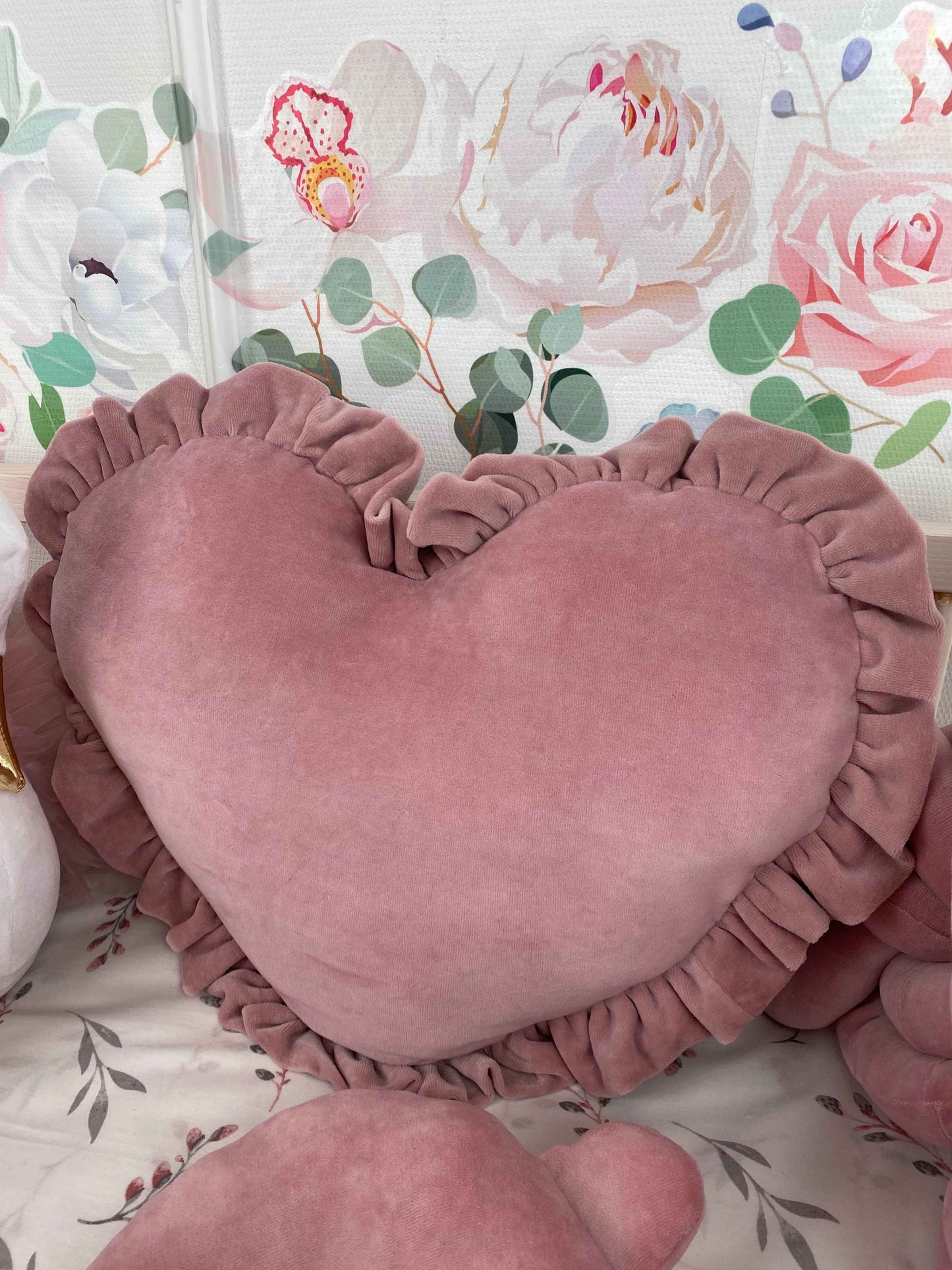 Heart shape plush pillow in rose color. Close up.