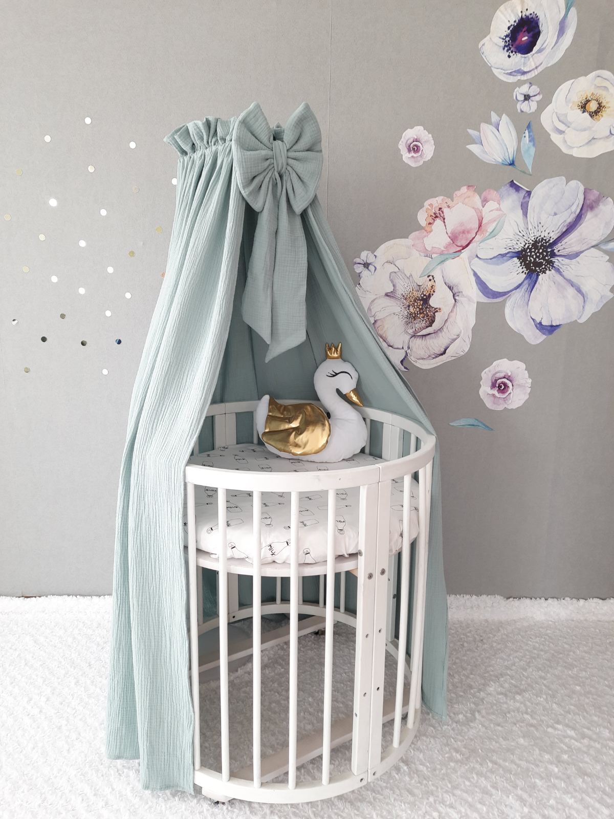 Sage green muslin canopy for cot. Swan pillow on the crib