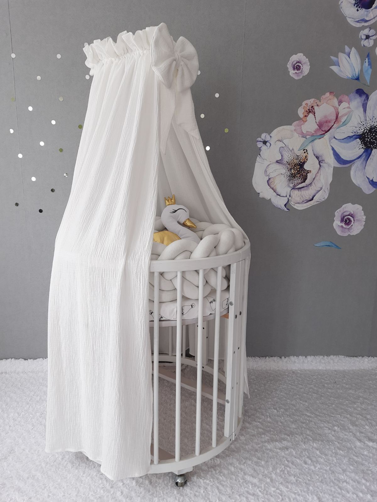 Natural muslin canopy in white color with bow. White braided bumper and swan pillow on the crib. White crib set for nursery 