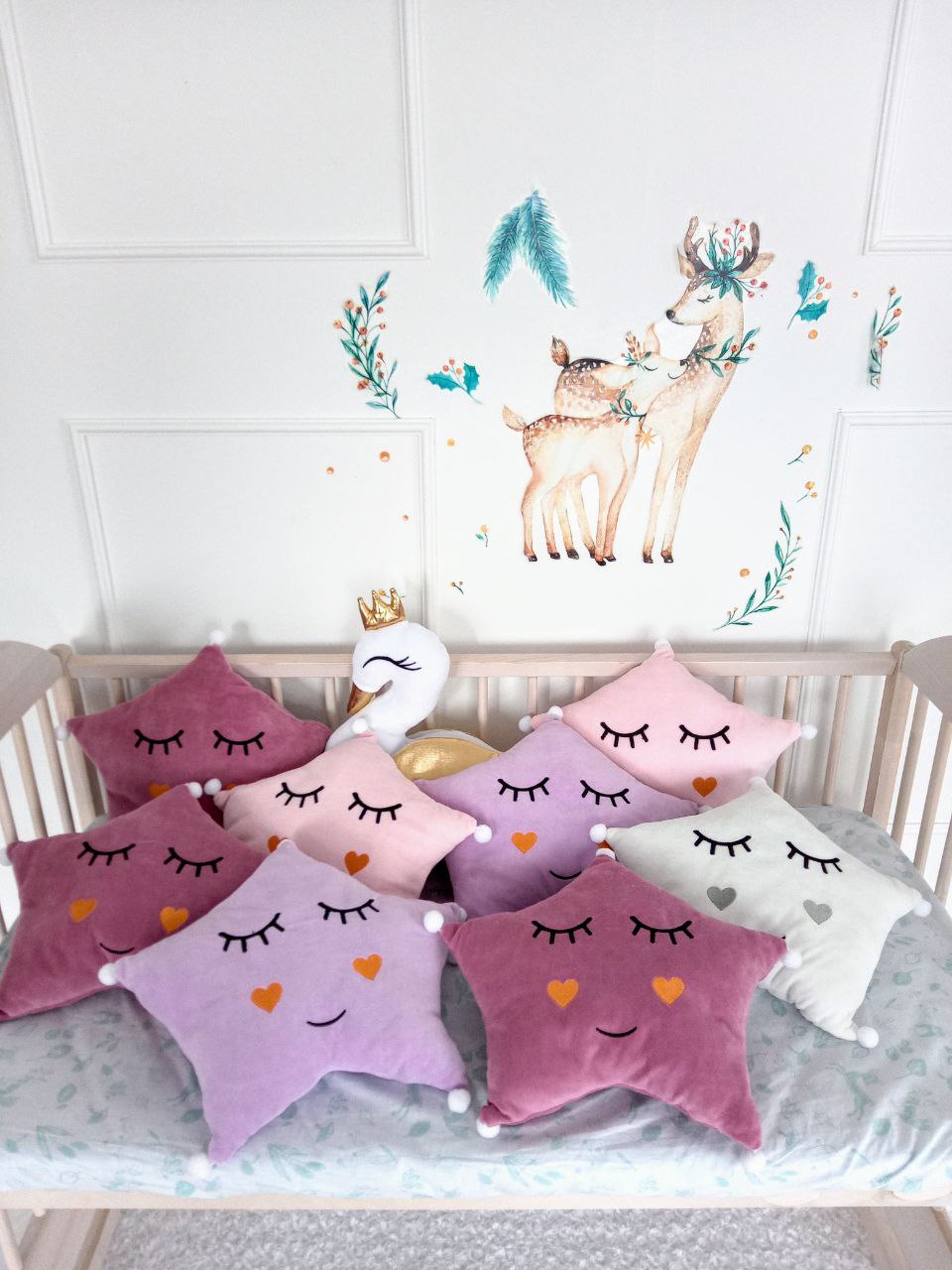 swan pillow and star pillows on the crib