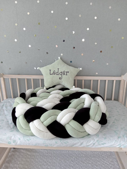 Light olive-black-white double braided crib bumper with light olive star pillow as a gift in the crib.