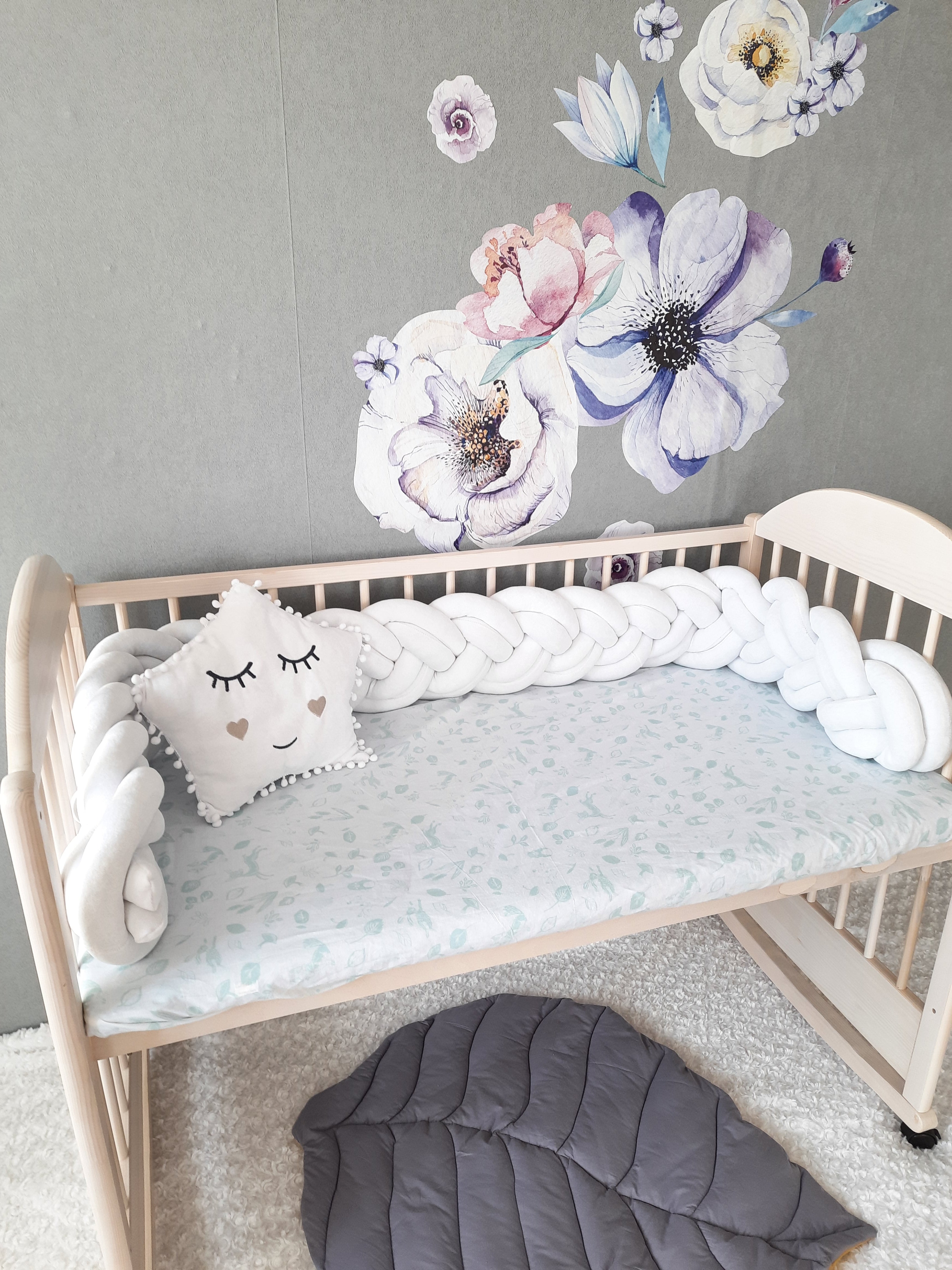 White Double Braided Bumper with white star pillow on the crib. Front side slightly angled from the left