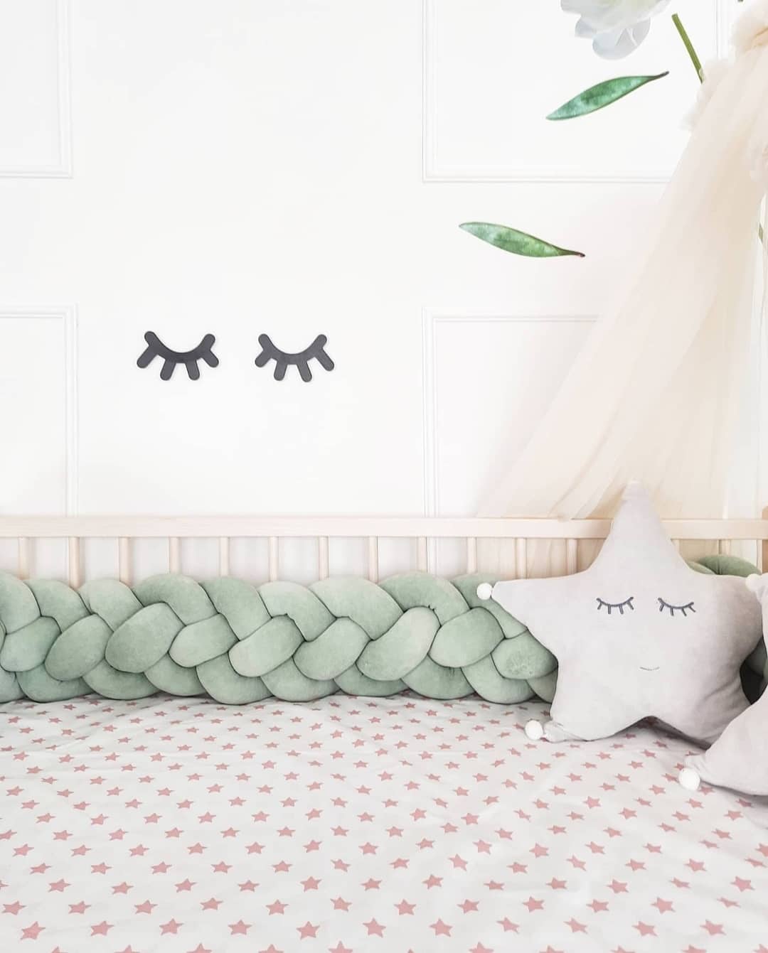 Light olive Weaving Braided Crib Bumper with gray star pillow on the crib