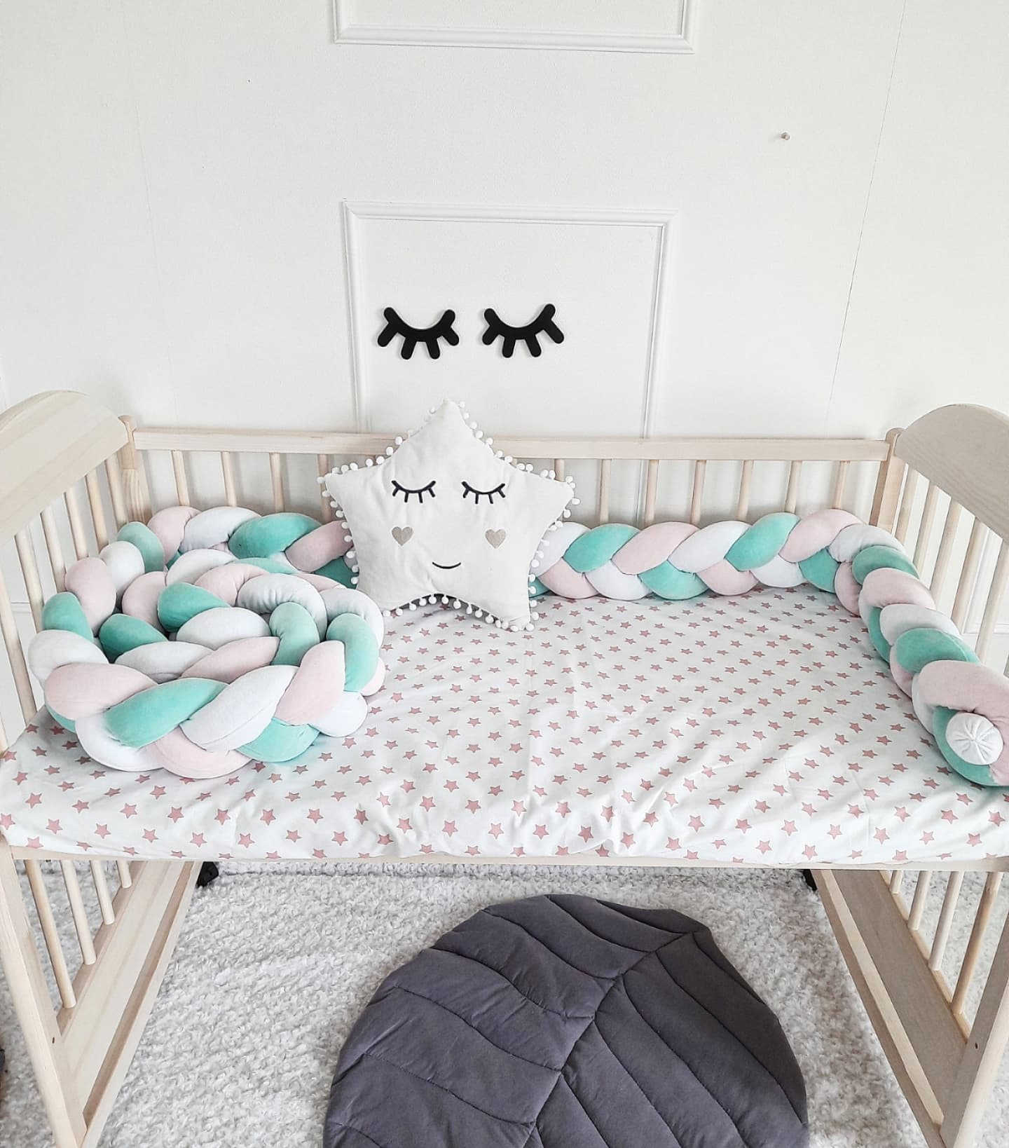 Triple Weaving Crib Bumper in white, mint and light pink colors with white star pillow on crib. Front side