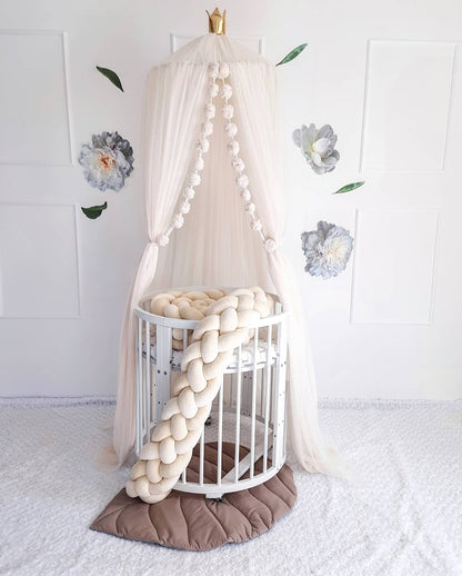 Ivory Nursery Canopy with ivory double braided bumper on the crib. In white nursery room. Front side.